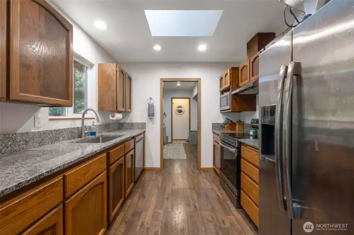 Kitchen offering solid surface countertops, stainless steel appliances and wood cabinets