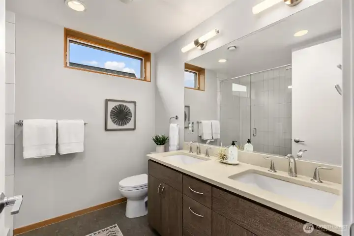 The shared upper level bathroom features a wide dual vanity with walk-in shower.
