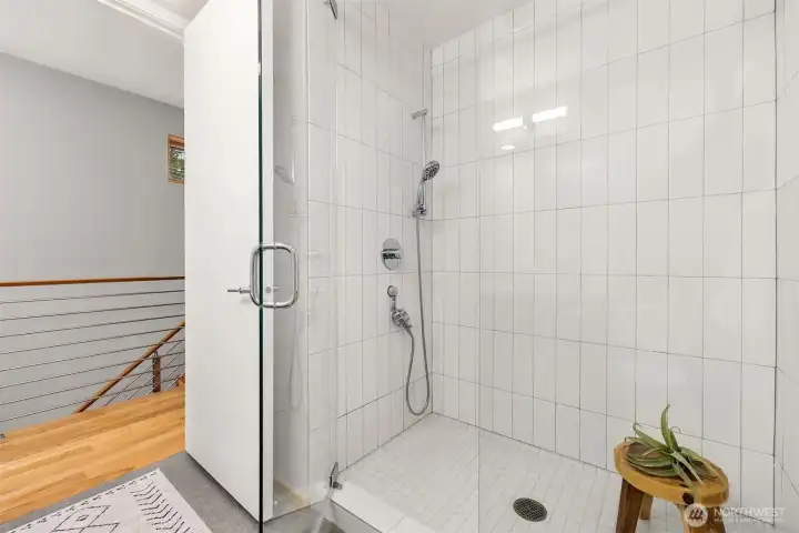 Spacious walk-in shower with glass surround.