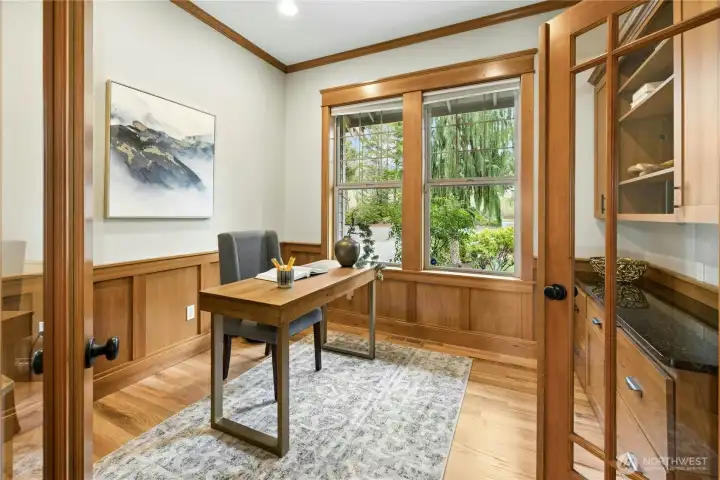The dedicated main floor office is just off the entryway and has thoughtful built-ins and warm wood finishes.