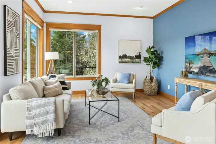 The bright and open living room features a propane fireplace,  large view windows, and a sliding door out to the view deck.