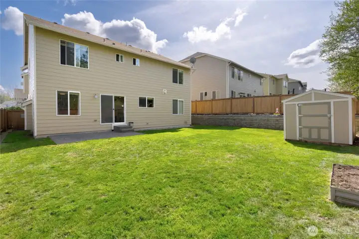Fully fenced backyard with engineered retaining wall