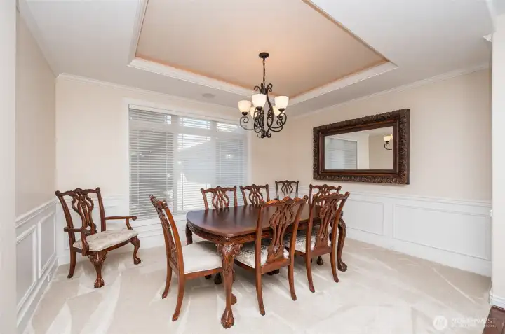 Formal Dining room off entry. Lighted coffered ceilings with crown molding, wainscoting, wood wrapped windows, hunter douglas silhouette blinds and new carpet. Furniture available for purchase Formal Dining room off entry. Lighted coffered ceilings with crown molding, wainscoting, wood wrapped windows, hunter douglas silhouette blinds and new carpet. Furniture available for purchase