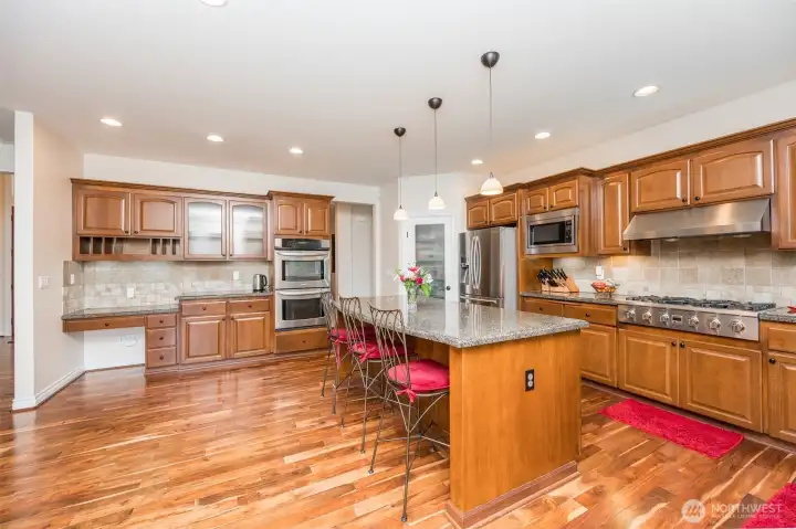Kitchen is the heart of the home off the family room - very open concept. Enjoy all the cabinet and counter space in this gourmet kitchen. The 7 foot island has cabinets and drawers and electrical outlets on both sides for your convenience. There is no shortage of cooking area with your double oven, 6 burner gas cooktop, microwave, and 4 drawer refrigerator with a newer bosch dishwasher for the clean up. Granite slab counters, travertine backsplash, lots of electrical outlets, walk-in pantry, and even a desk area Kitchen is the heart of the home off the family room - very open concept. Enjoy all the cabinet and counter space in this gourmet kitchen. The 7 foot island has cabinets and drawers and electrical outlets on both sides for your convenience. There is no shortage of cooking area with your double oven, 6 burner gas cooktop, microwave, and 4 drawer refrigerator with a newer bosch dishwasher for the clean up. Granite slab counters, travertine backsplash, lots of electrical outlets, walk-in pantry, and even a desk area