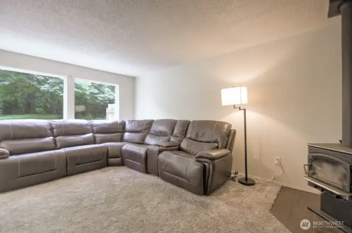 Newer carpet in living room with wood stove