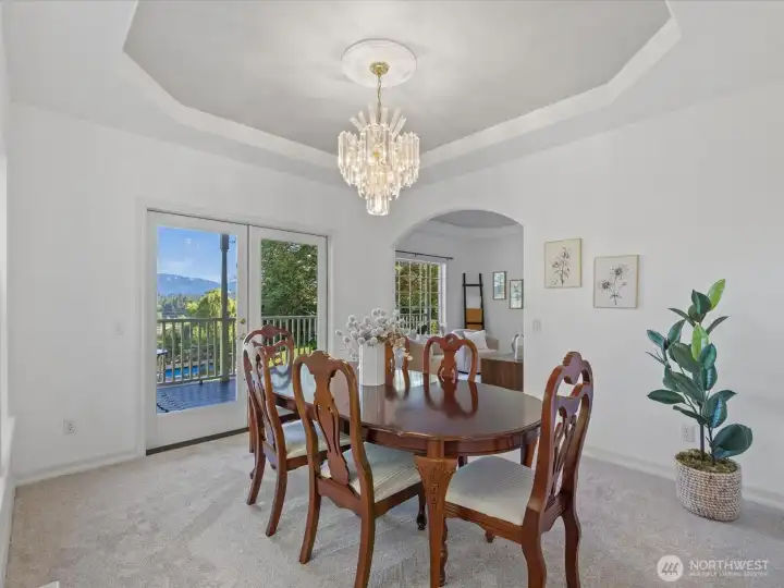 Formal dining room with mountain views, tray ceiling, and French doors to covered patio