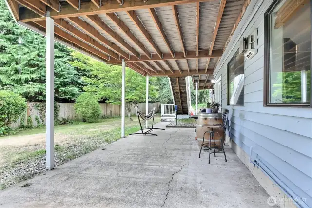 Ground floor concrete patio (slider entry just past the table / chairs in view).