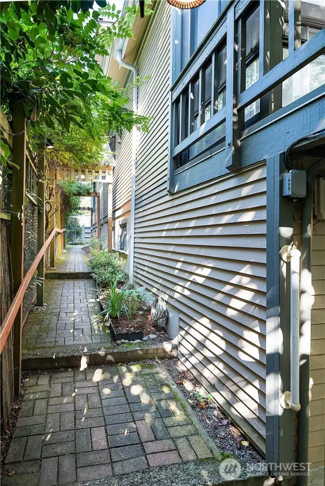 Path along the west side of the house leads to the lower backyard units. This view is looking north towards the front of the house.