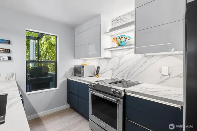 This modern kitchen boasts custom cabinets, high-end countertops, premium appliances, and a sleek backsplash—where style meets function.