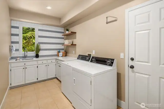 Remodeled laundry room with new quartz counters and tiled back wall. Open shelving for Pinterest worthy storage! Washer and dryer go with seller.