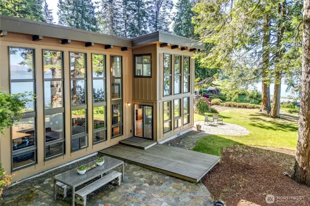 The water side of the home shows off the beautiful floor to ceiling windows and the grounds are exceptional