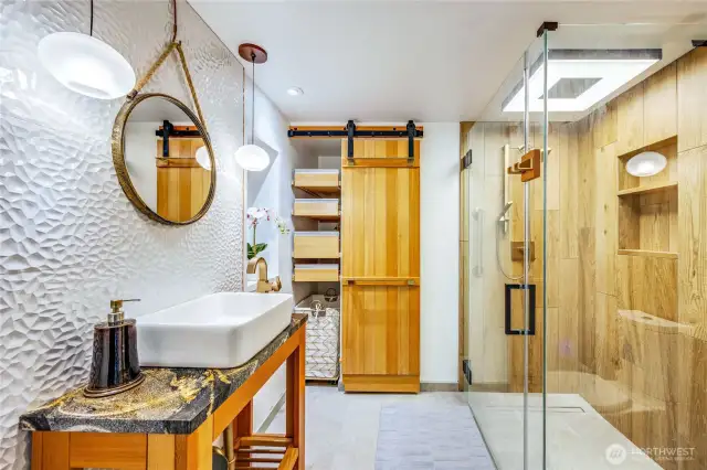 Beautiful main floor bath with heated floors, glass shower and barn door storage.