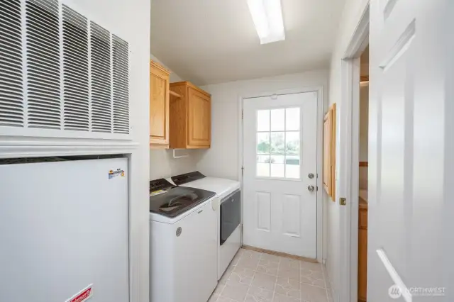 Laundry with 1/2 bath which has a large utility sink, and patio/backyard access.