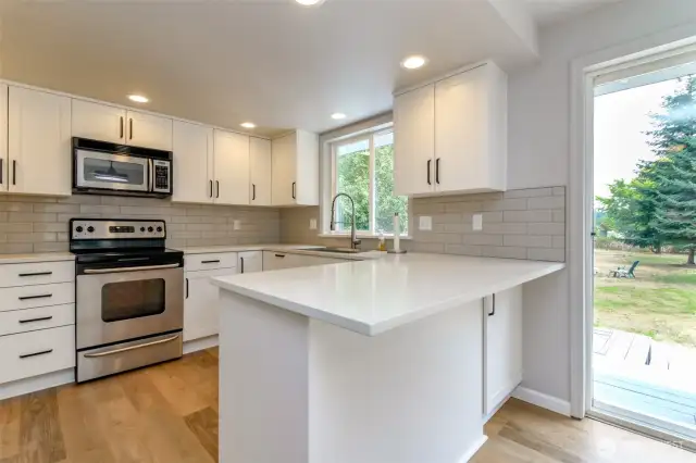 This kitchen is lovely!  It was just remodeled with new cabinets, quartz countertops, stainless appliances, tile backsplash, breakfast bar,  recessed lighting, and walk in pantry!