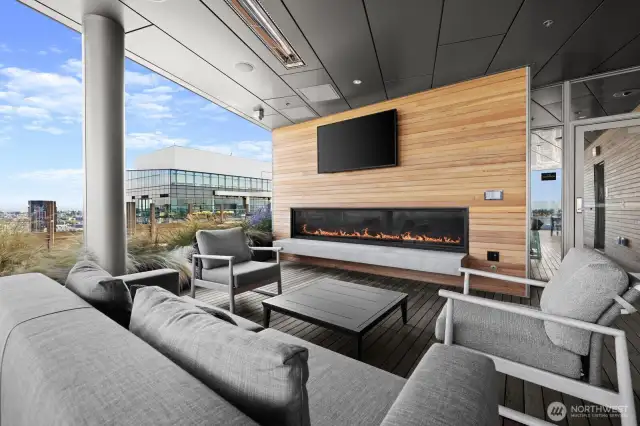 Outdoor lounge area with gas fireplace and TV.