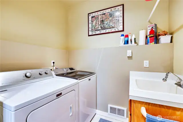 Laundry area just off the kitchen, utility sink and Maytag washer and dryer.