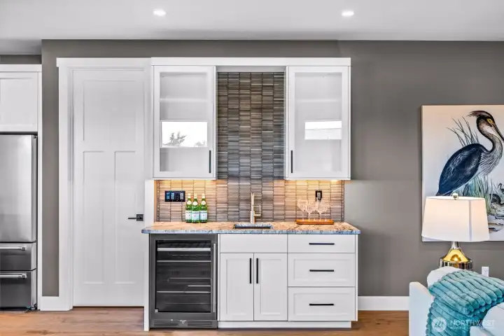 Wet bar with wine refrigerator making it a perfect space or a coffee station, wine service or buffet set up. Door to left leads to the amazing walk in pantry.