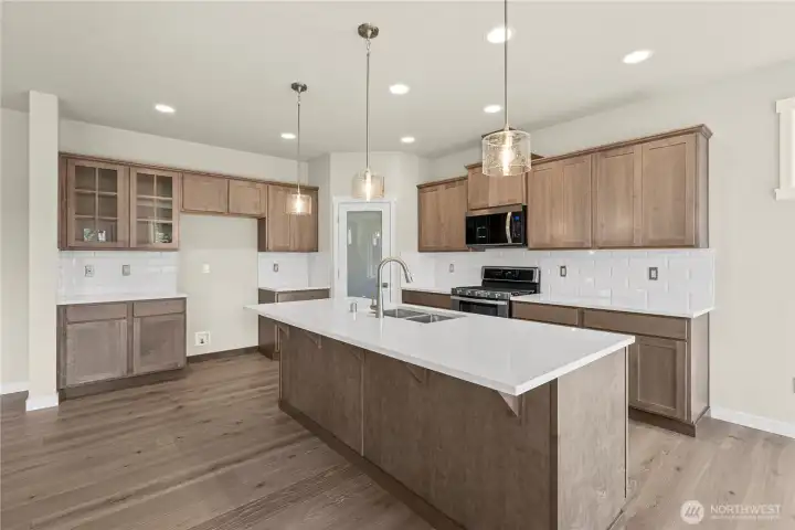 Modern kitchen design with Quartz countertops and full tile backsplash.