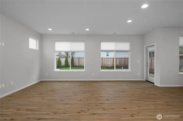 Expansive living space with large windows overlooking the backyard, creating a bright and inviting atmosphere.