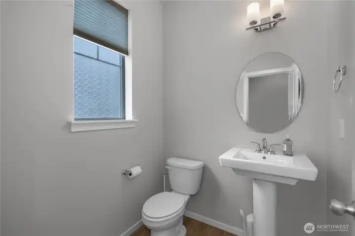 Convenient main floor powder room with modern fixtures and natural light.