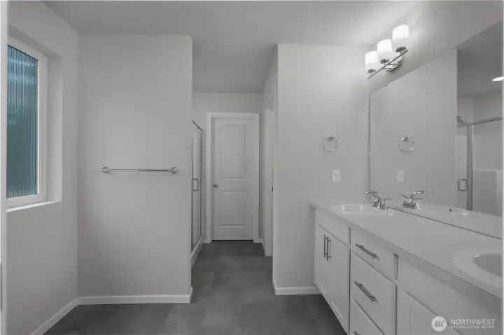 Primary bath with dual vanities, modern fixtures, and ample storage.
