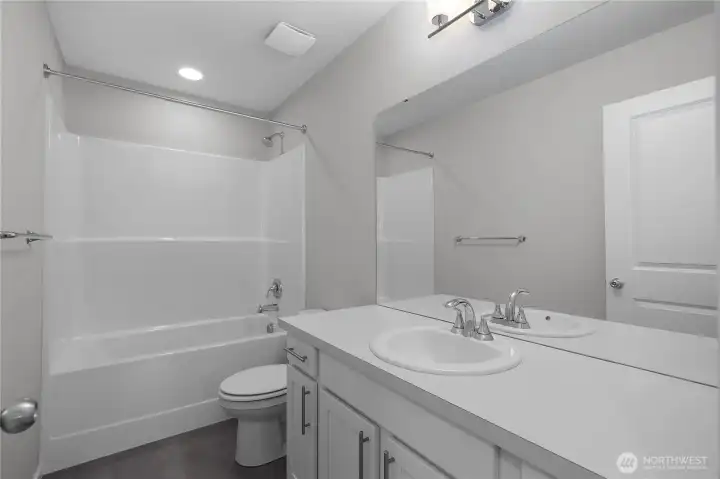 Hall Bath Full - Clean, modern bath with large mirror and sleek fixtures.