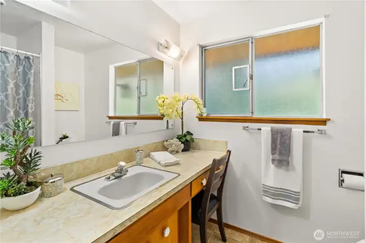 Full bath on main floor features solid wood cabinetry and built in vanity