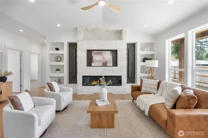 Large stone fireplace anchors the living area. Contemporary lighting and fixtures, custom builtins.