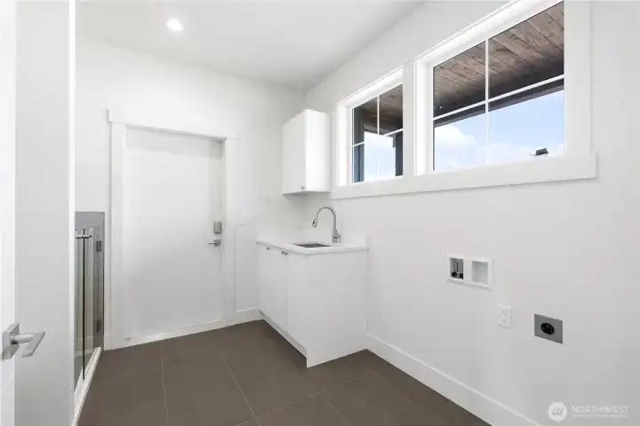 Laundry and mudroom off of the garage. Tile floor, built-in cabinets and sink. Wired for electric or gas dryer. Windows for light.