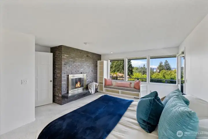 primary bedroom with fireplace, built in seating and private deck access