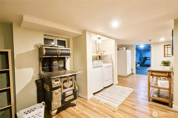The utility/laundry room is located off the garage in the daylight basement. (Workout room is seen in the distance) The utility/laundry room is located off the garage in the daylight basement. (Workout room is seen in the distance)