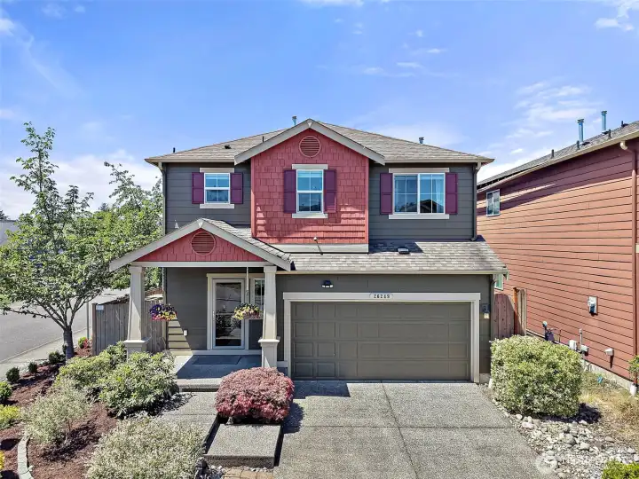 Move-In Ready Two-Story Home on a Desirable Corner Lot with Charming Curb Appeal, Covered Front Porch, Low-Maintenance Landscaping, and Attached Garage in the Heart of Maple Valley.