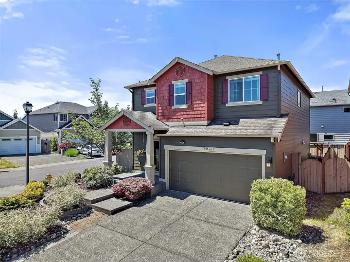Move-In Ready Two-Story Home on a Desirable Corner Lot with Charming Curb Appeal, Covered Front Porch, Low-Maintenance Landscaping, and Attached Garage in the Heart of Maple Valley.