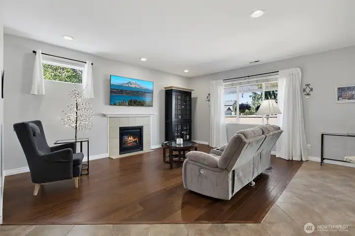 Bright and inviting living room featuring a cozy gas fireplace, abundant natural light, and an open layout designed for comfortable everyday living and entertaining.