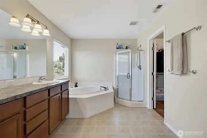 Spacious primary bath featuring dual-sink vanity, soaking tub, separate shower, and the comfort of a private en-suite retreat.