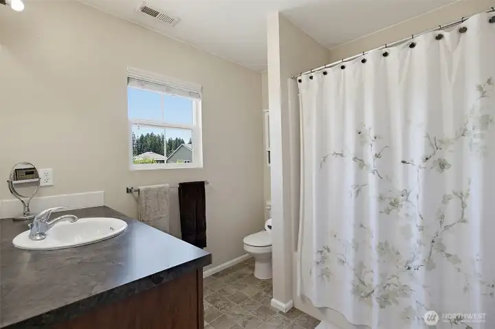 Spacious bath featuring dual sinks, soaking tub, and separate shower.