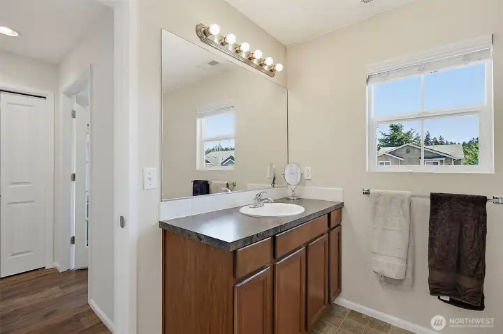 bathroom with dual vanity and abundant natural light.