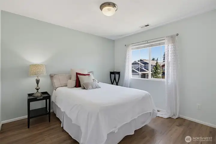 Bright and versatile secondary bedroom featuring abundant natural light, durable flooring.