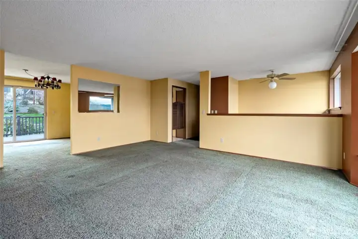 View toward dining, kitchen and hallway.  Ceiling fan is over entry way.