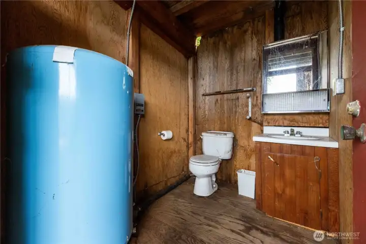Half bath with well pressure tank.
