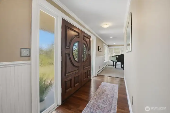 Bright foyer with hardwood flooring and spacious entryway.