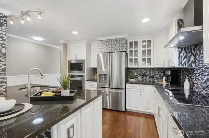 Bright kitchen showcasing premium finishes, stainless appliances, and functional workspace.