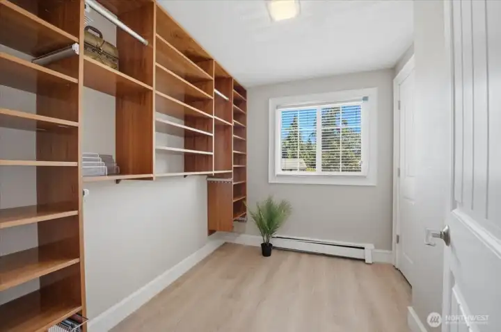 Walk-in closet with custom built-in shelving and organization system.