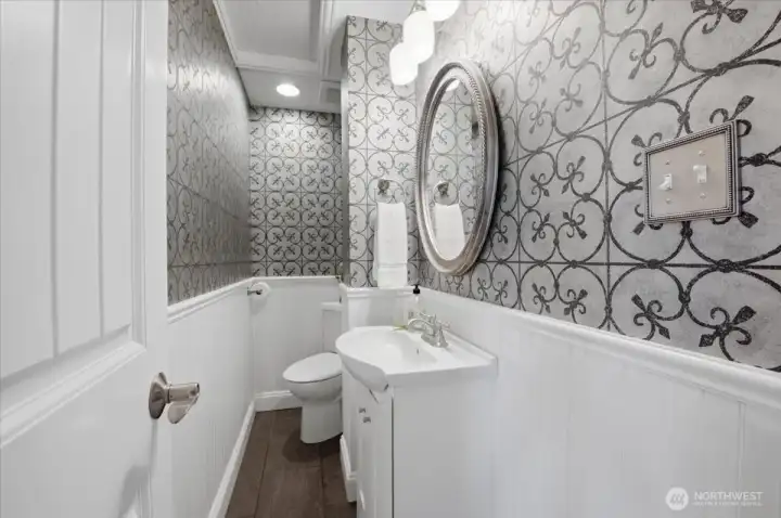 Stylish powder bathroom with designer wallpaper and updated vanity.