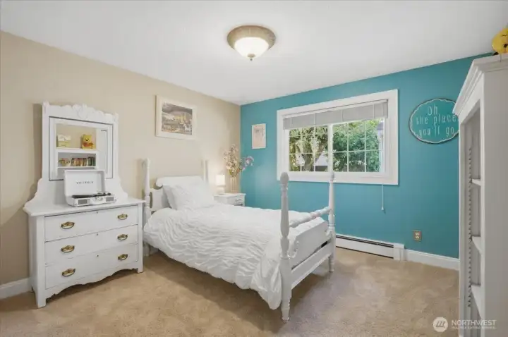 Spacious secondary bedroom with large window and neutral décor.