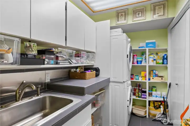 Laundry room with sink and plenty of cabinets for storage.