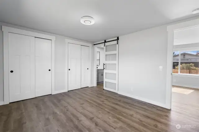 Dual closets in Primary Suite with barn door leading into private bathroom.