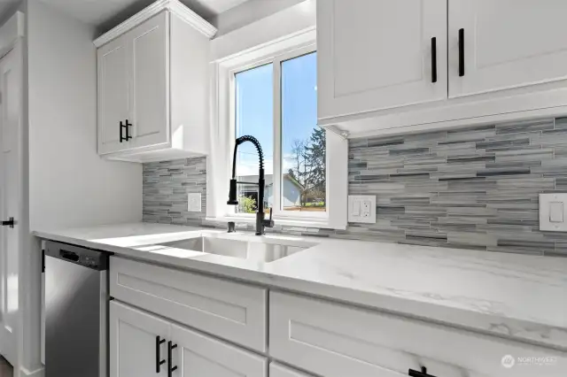 Undermounted stainless steel sink for easy clean-up with modern goose-neck faucet.