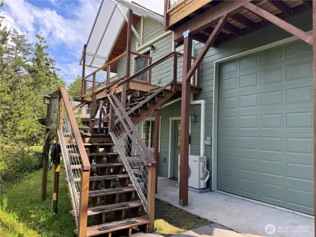 Private exterior entrance to upper level ADU guest studio. Brand new decking. Lower access to interior stairway to upper studio and laundry as well as a second doorway to the 2 car garage and large RV bay.