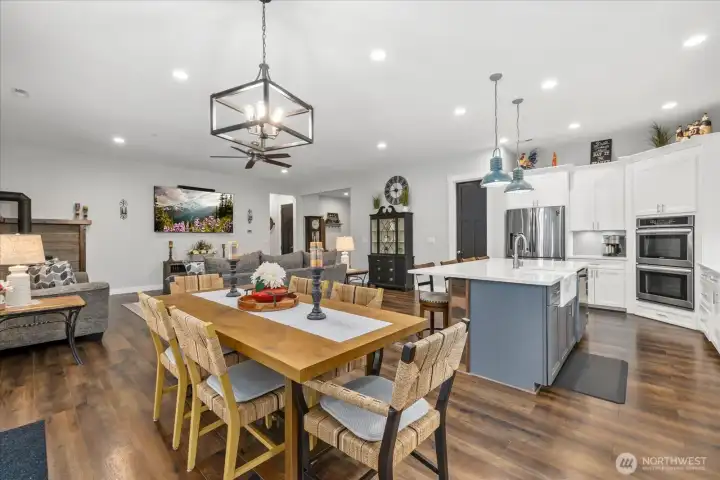 Large dining area open to living area and separate coffee bar to the right with custom shelves.